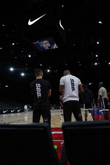 Behrad & Denzel from Simply British Ballers. (SBB.) stand court side on the NBA Paris Court, creating content whilst a Henessey event is ongoing prior to the NBA Paris 2023 game. 